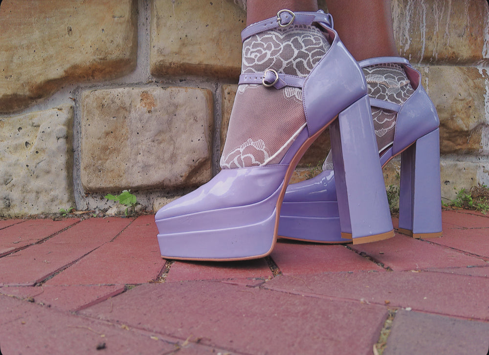 Side view of white lace ankle socks with delicate trim, styled with open-toe heels – feminine fashion accessory