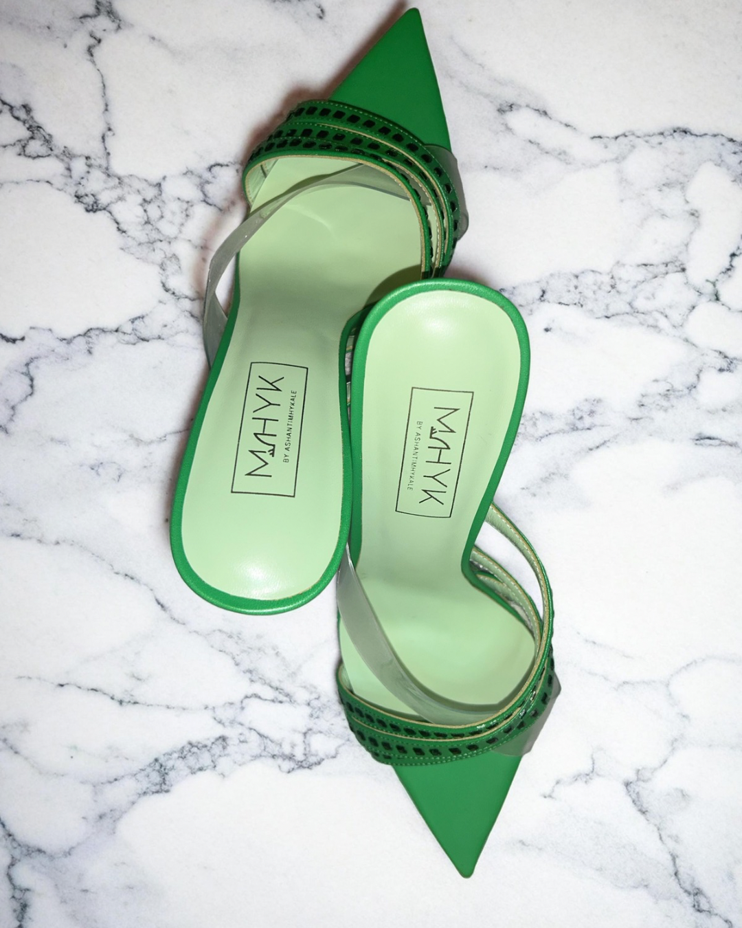 Envy green mules shown from the back, displaying the open heel design, smooth upper, and clean lines of the sho