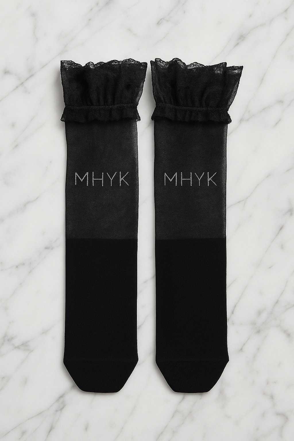 MHYK Original over-the-knee lace socks laid flat in aerial view on a white marble slab, showing intricate lace pattern and scalloped edges.