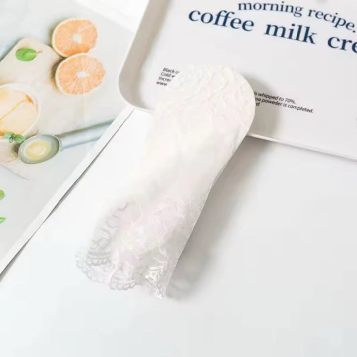 Flat lay of white lace ankle socks with floral trim – soft, breathable accessory for heels and sanda