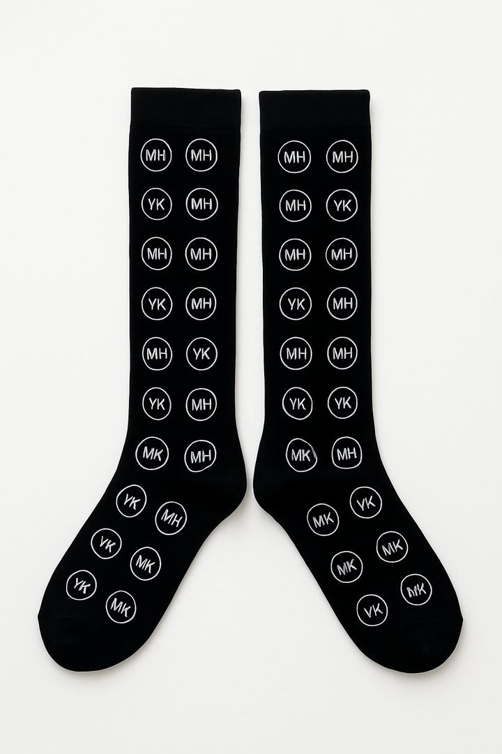 Flat lay- studio background of black and white embroidered socks. 